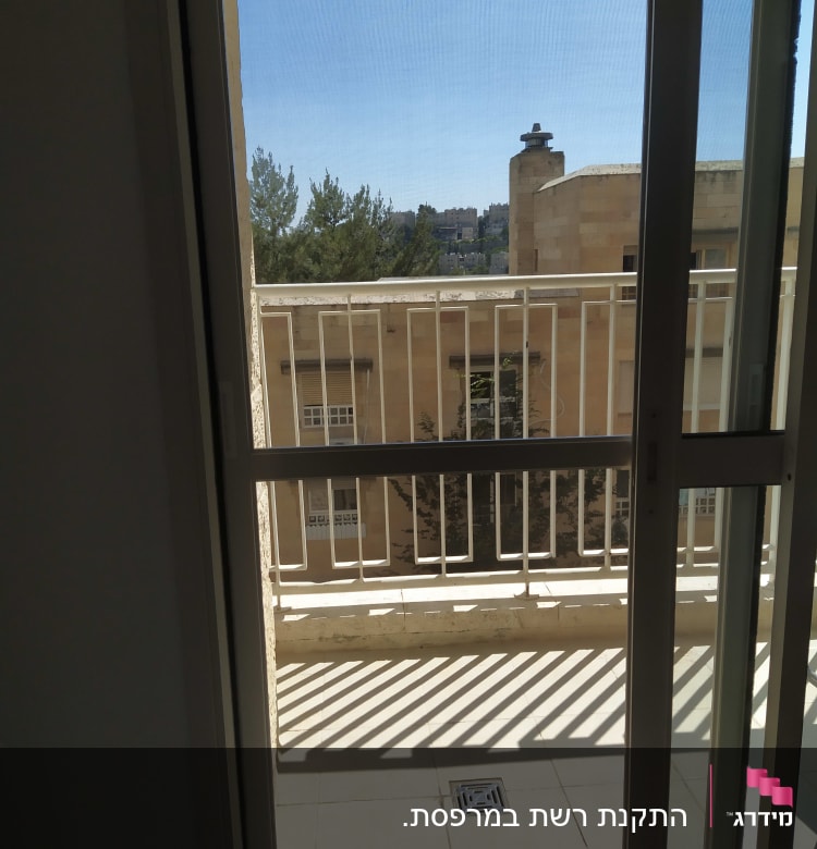 מעקה אלומיניום במרפסת עם צללים על הרצפה